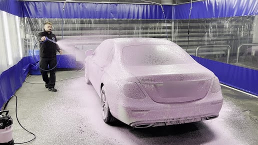 A car covered in foam before the hand wash in the Premium Autopesu workshop
